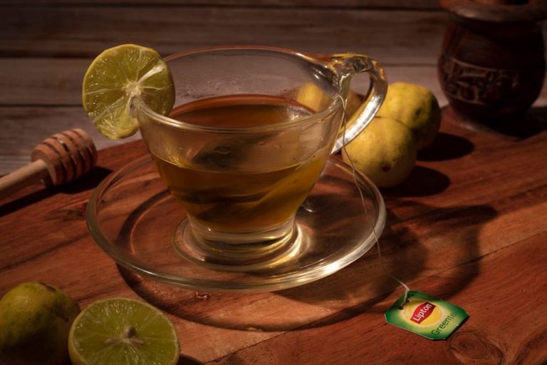 чашка зелёного чая с лимоном на столе
